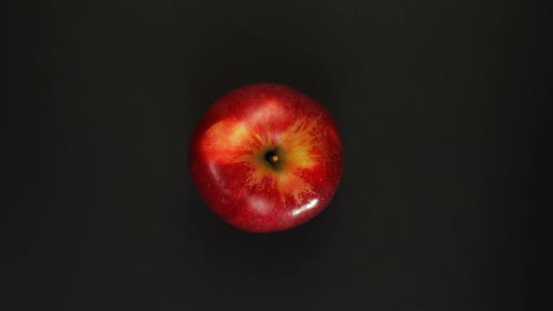 Roterande rött äpple på en svart bakgrund isolat. Färsk juice, frukt, vitamin och sommarkoncept. — Stockvideo