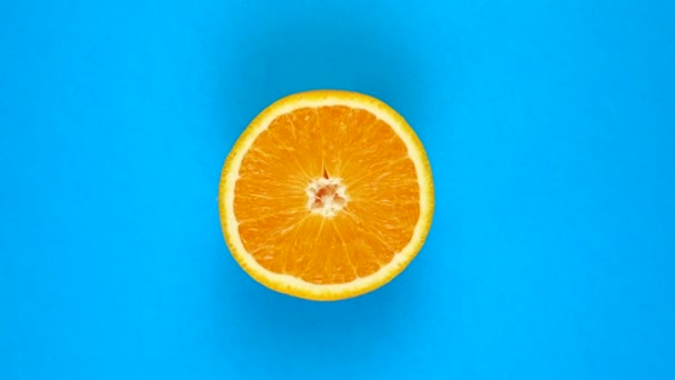 Обертання соковитого апельсина ізольовано на синьому. Обертання на 360 градусів. Фрукти з апельсинового дерева . — стокове відео