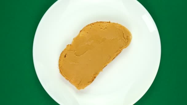Sandwich de mantequilla de maní gira sobre un fondo verde. — Vídeo de stock