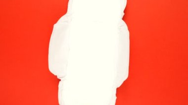 Regl hijyenik pedi yavaşça kırmızı arkaplanda dönüyor..