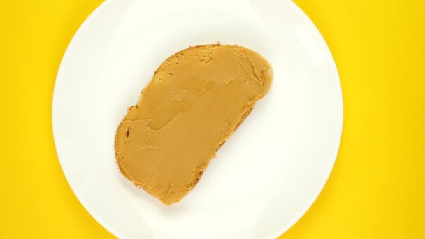 Peanut butter, jam sandwich rotating, turning round on yellow background. — 图库视频影像