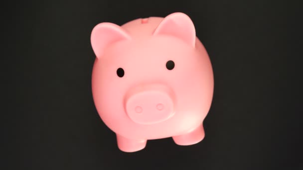 Rotation of a piggy bank isolated on black. 360 degree rotation. Savings concept. — Stockvideo