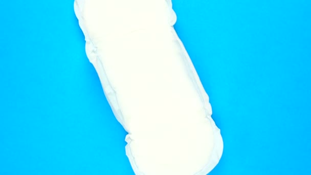 Female menstrual pad rotates on blue background — Video Stock