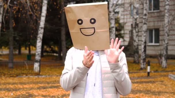 Sonriente hombre con bolsa de papel con emoción feliz, hombre con máscara de pie al aire libre y aplaudiendo — Vídeos de Stock