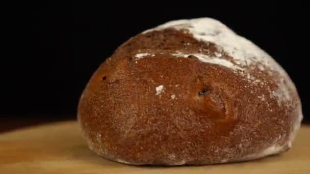 Pane integrale di pane lievitato naturale ruotante velocemente su tavolo di legno, isolato su nero — Video Stock