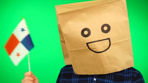 Retrato de homem com saco de papel na cabeça acenando bandeira do Panamá com rosto sorridente contra fundo verde. — Vídeo de Stock