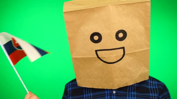 Πορτρέτο του ανθρώπου με χάρτινη τσάντα στο κεφάλι κυματίζει σλοβακική σημαία με χαμογελαστό πρόσωπο σε πράσινο φόντο. — Αρχείο Βίντεο