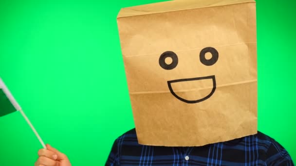Πορτρέτο του ανθρώπου με χάρτινη τσάντα στο κεφάλι κυματίζει ουαλική σημαία με χαμογελαστό πρόσωπο σε πράσινο φόντο. — Αρχείο Βίντεο