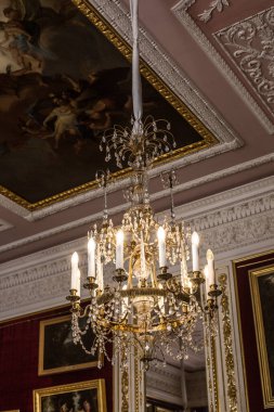 Tavanın altında antik metal bir avize var.