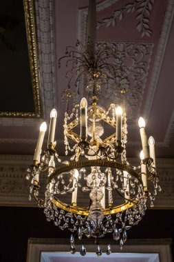 Tavanın altında antik metal bir avize var.