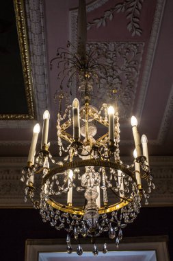 Tavanın altında antik metal bir avize var.