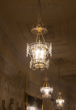 Tavanın altında antik metal bir avize var.