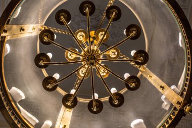 Tavanın altında antik metal bir avize var.