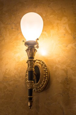 Tavanın altında antik metal bir avize var.