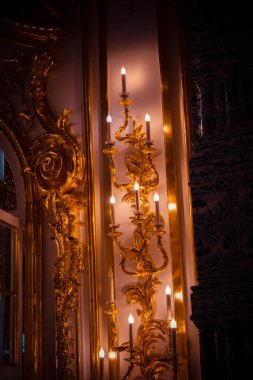 Tavanın altında antik metal bir avize var.