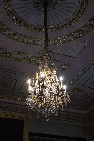 Tavanın altında antik metal bir avize var.