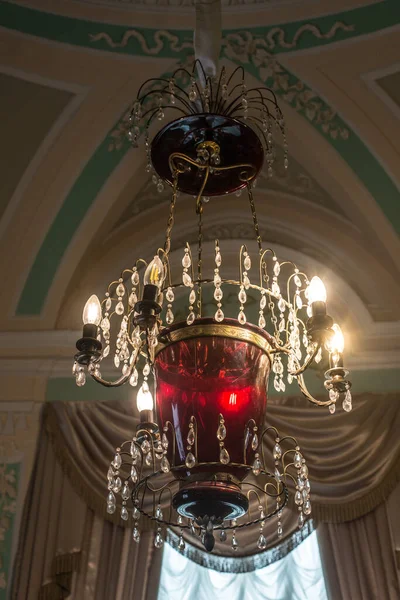 Tavanın altında antik metal bir avize var.