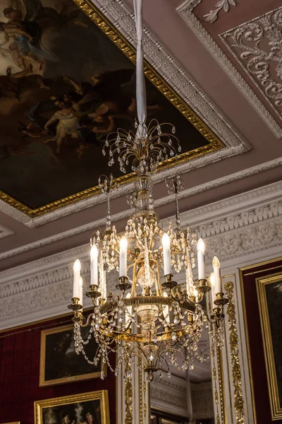 Tavanın altında antik metal bir avize var.