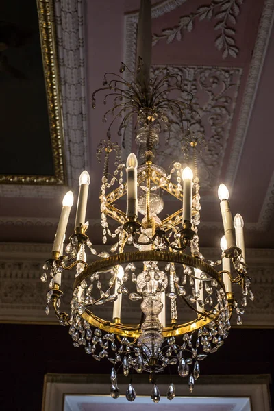 Tavanın altında antik metal bir avize var.