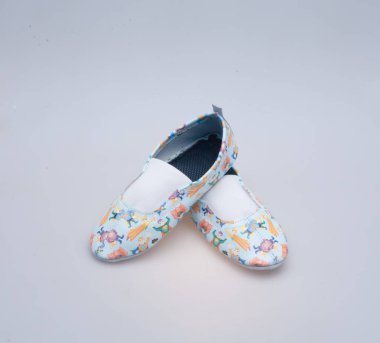 Beyaz arka planda yakın plan desenli deri ayakkabılar.