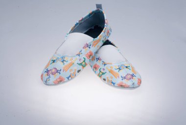 Beyaz arka planda yakın plan desenli deri ayakkabılar.