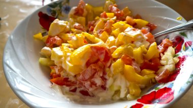 Sebze salatası ve ekşi krema sosuyla mayonezi yakın plan bir tabakta. 