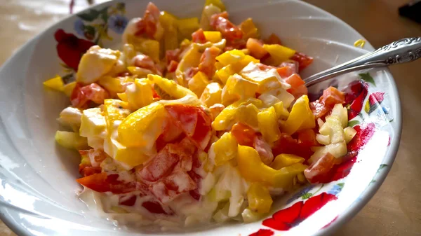 Sebze salatası ve ekşi krema sosuyla mayonezi yakın plan bir tabakta. 