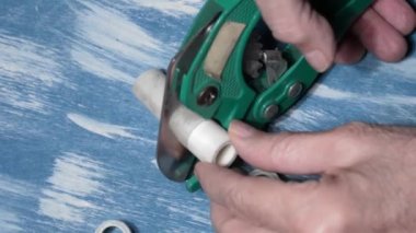 Tesisatçı lehimlemeden önce metal-plastik boruları keser. Kapat.