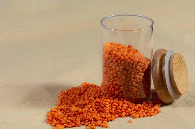 Kumaş zemin üzerinde cam kavanozda kırmızı mercimek