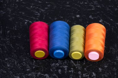 Siyah arkaplanda renkli makaralar