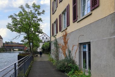 Sonbaharda Limmat nehri kıyısında sessiz bir cadde. Baden, Aargau Kantonu, İsviçre.