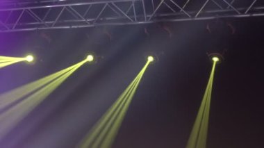 Sahne ışıkları çerçevesinin animasyonu. Parlak sahne ışıkları yanıp sönüyor. Karanlık, yeşil ışık projektörlerindeki spot ışıkları siyah arka plana vuruyor..