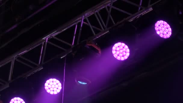 Kleurrijke projectoren hangen op een muzikale boerderij. Spotlights draaien en glinsteren in de concertzaal. Automatische verlichtingstechnologie. — Stockvideo