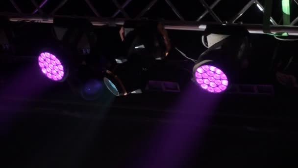 Projetores coloridos pendurados em uma fazenda musical. Holofotes girando e brilhando na sala de concertos. Tecnologia de palco de iluminação automatizada. — Vídeo de Stock