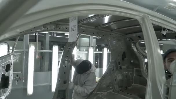 Checkman ellenőrzi összeszerelése autótest előtt festés folyamat. Autógyár. — Stock videók