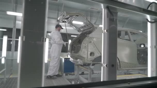 Checkman está comprobando el montaje de las carrocerías del coche antes del proceso de pintura. Fábrica de fabricación de automóviles. — Vídeo de stock