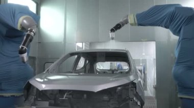Robot silah spreyi araba imalat fabrikasında bir araç cesedi boyuyor.