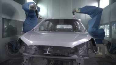 Robot silah spreyi araba imalat fabrikasında bir araç cesedi boyuyor.
