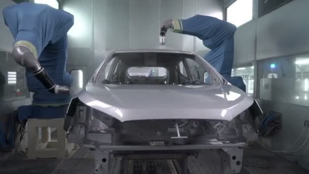 Роботизовані руки розпилюють фарбування кузова автомобіля на заводі з виробництва автомобілів — стокове відео