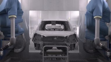 Koşu bandındaki araç parçalarını boyamak. Araba üretim fabrikası. İki ressam çarpışan bir arabaya beyaz boya sıkarlar..