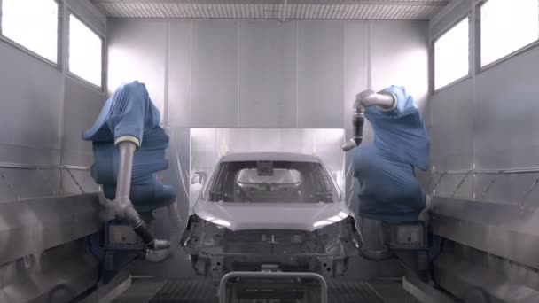 Роботизовані руки розпилюють фарбування кузова автомобіля на заводі з виробництва автомобілів — стокове відео