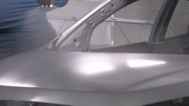 Robot silah spreyi araba imalat fabrikasında bir araç cesedi boyuyor.