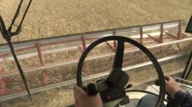 Direksiyondaki Erkek Eller Çiftçi Sürücüsü tarım alanında hasat topluyor. İçeriden Görüntüle.