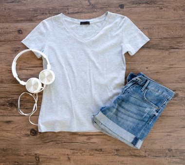 Grey T-shirt and jeans mock up  with headphone flat lay on wooden background. Top vie