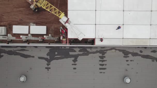 Légi felvétel. A munkások egy ipari épület tetejét szerelik össze. Megerősített betonpadló az építkezésen — Stock videók