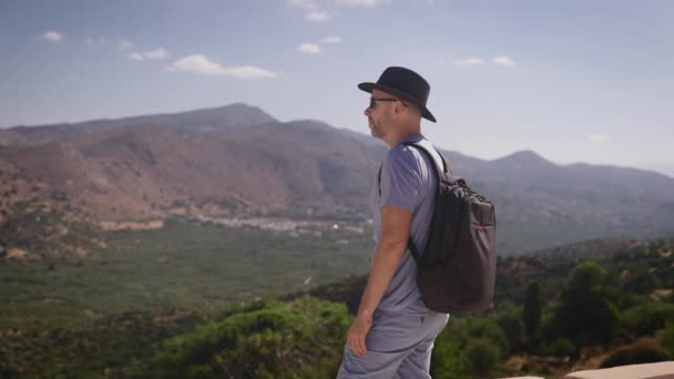 Boldog turista egy hátizsák élvezi a gyönyörű kilátás nyílik a völgyre és a hegyekre. Nyár — Stock videók