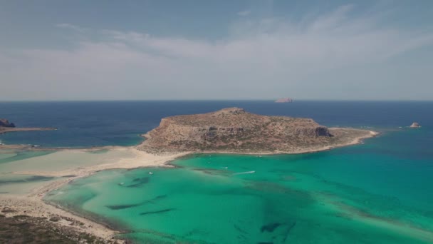 Vista aérea. La hermosa bahía de Balos en la isla griega de Creta. Un hombre y una mujer de pie en un acantilado con una hermosa vista. — Vídeo de stock