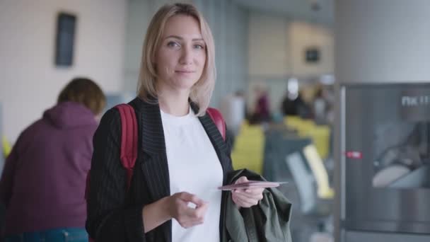 Привлекательная молодая женщина в аэропорту ждет своего отъезда. Документы — стоковое видео