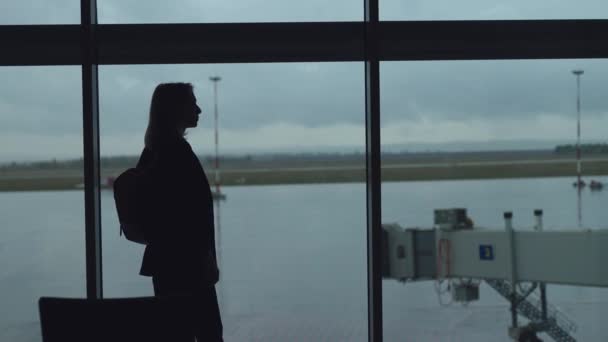 Silhouetten van een jonge vrouw op de luchthaven. — Stockvideo