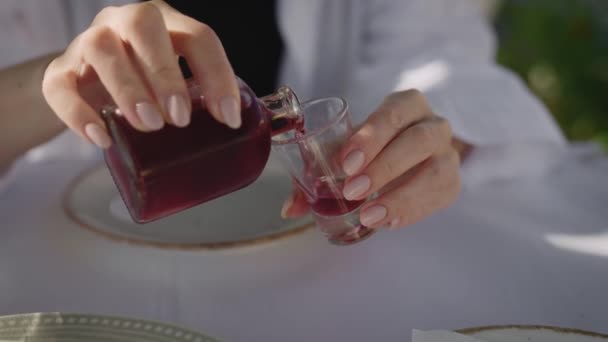 Manos femeninas vertiendo una inyección de tintura roja de una botella pequeña. — Vídeos de Stock